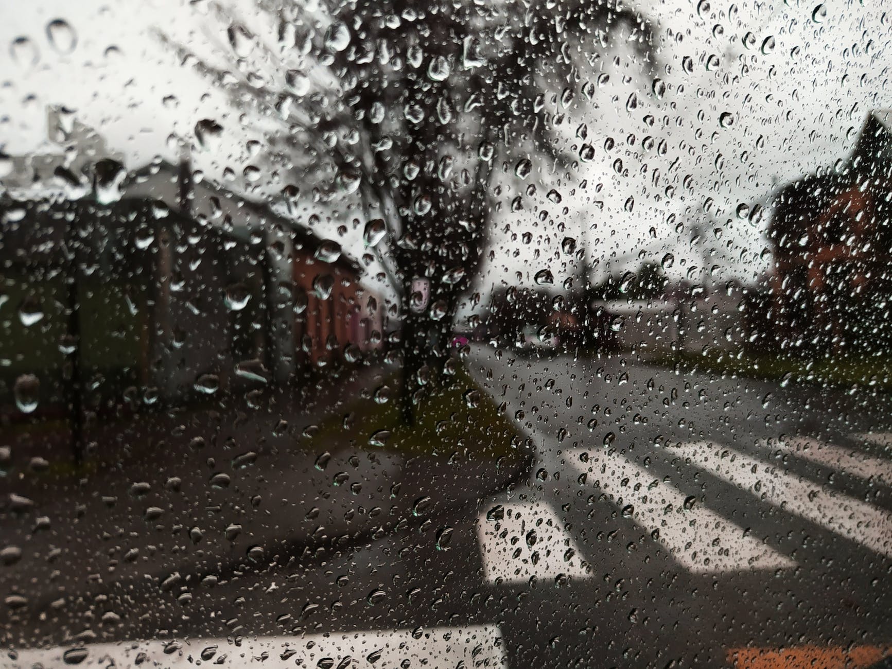 view through glass on street in rain