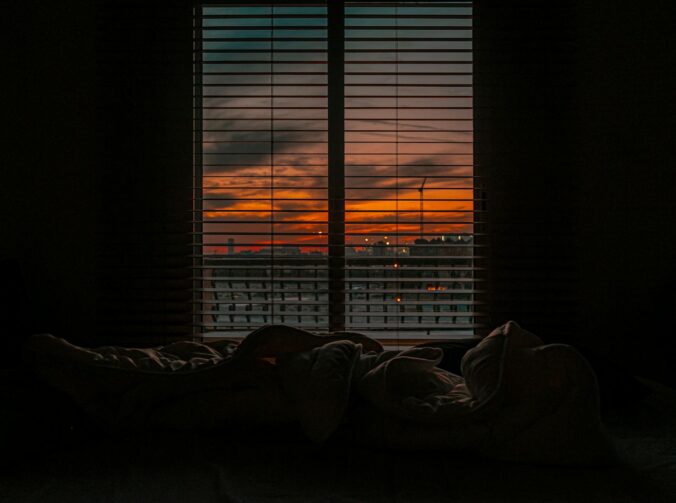 crumpled blanket in dark room at sunset